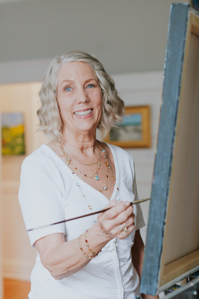 Artist smiling and standing at easel