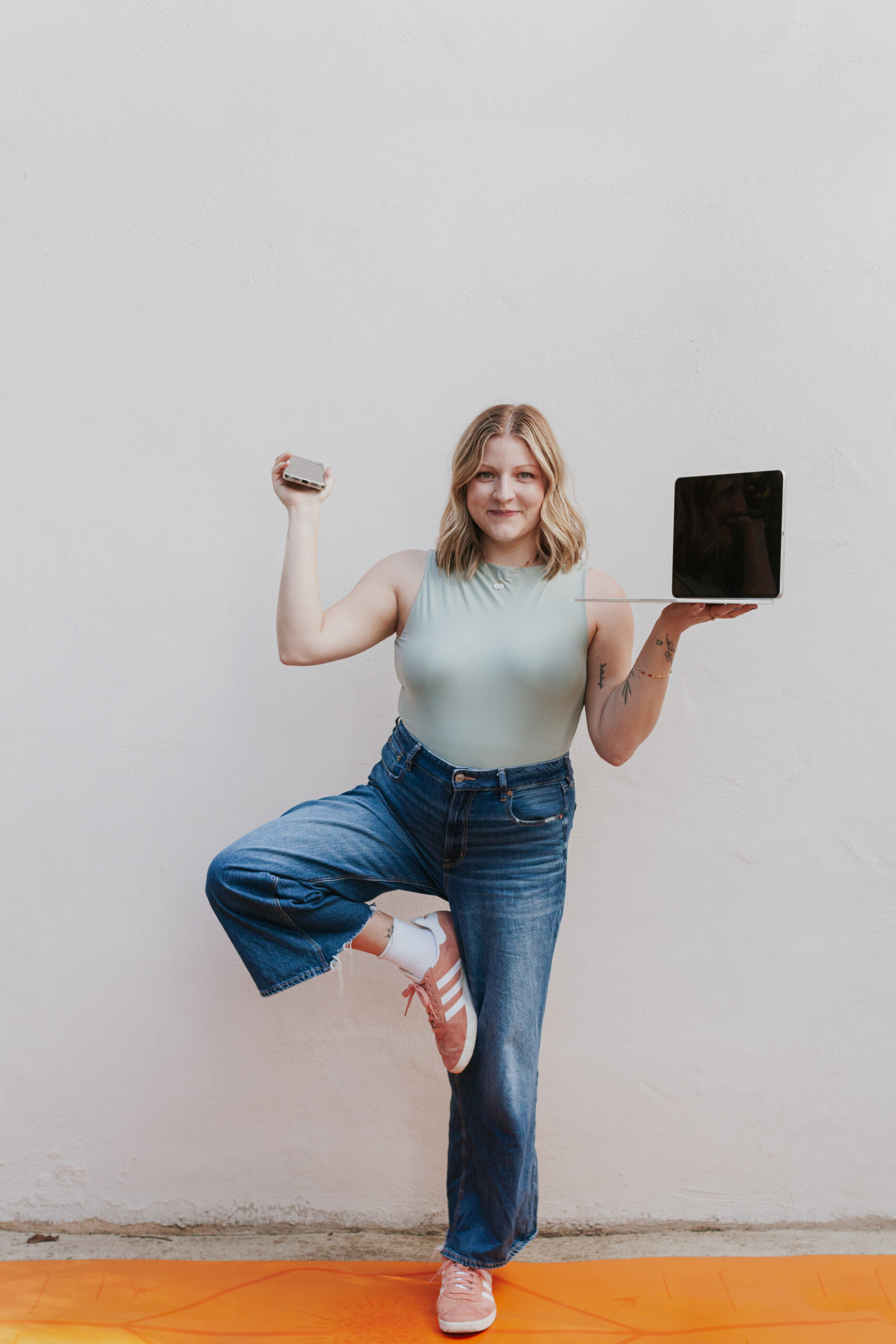 woman in tree pose with phone and laptop