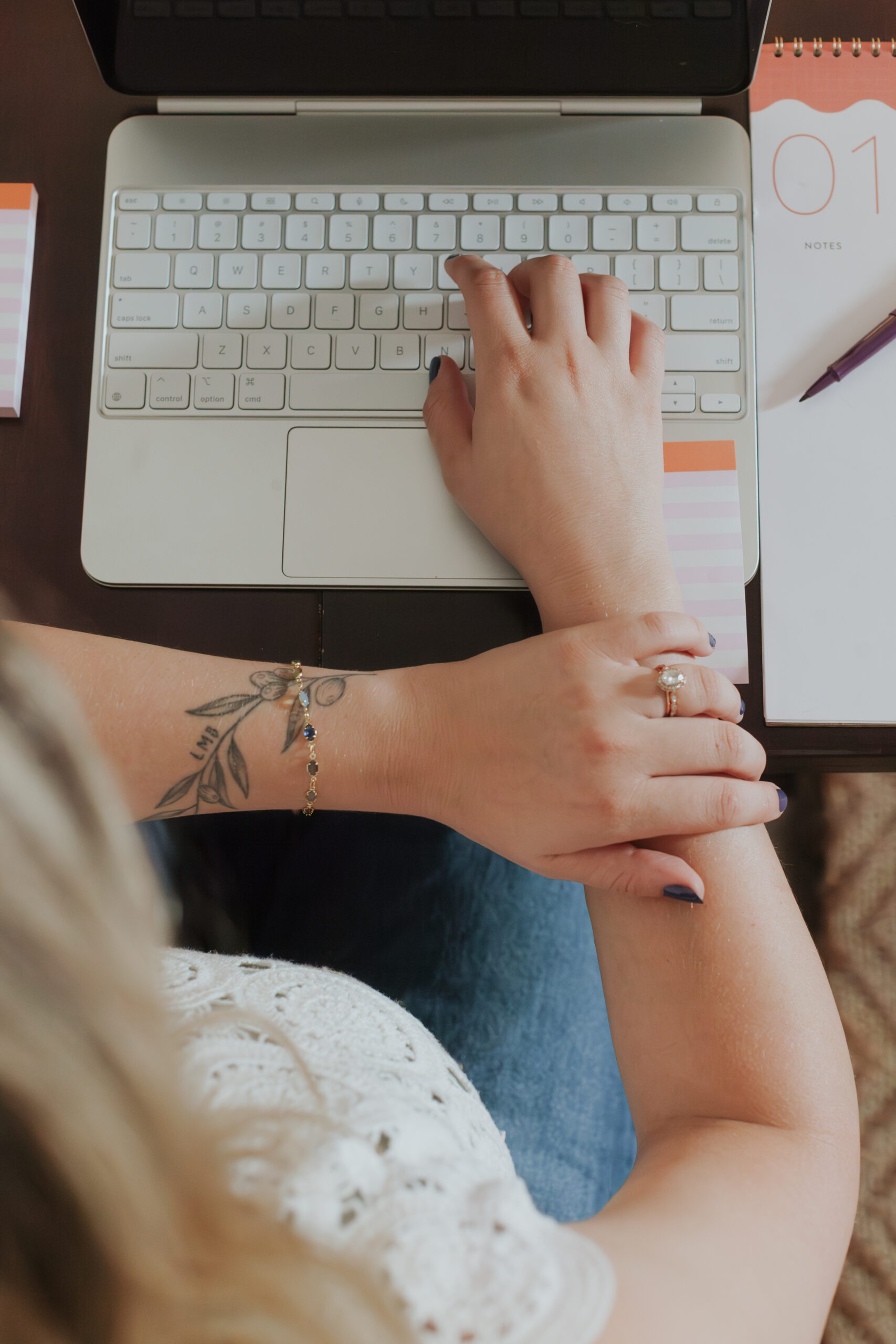 detail of woman's hands typing on laptop